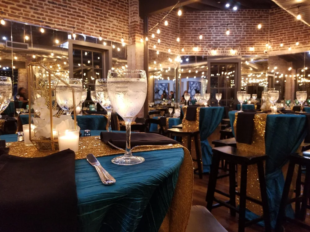 Industrial bar area with teal linens and string lights