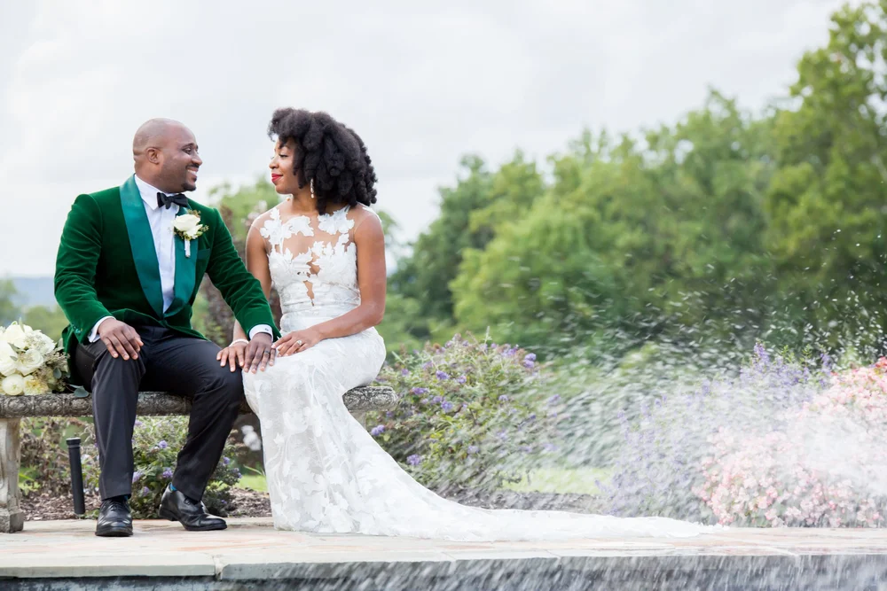 Couple seated on a wall, groom in green