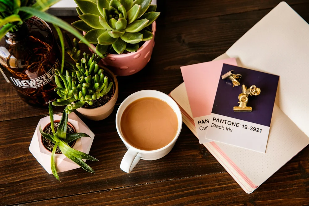 Desk flat lay with coffee, succulent and cards