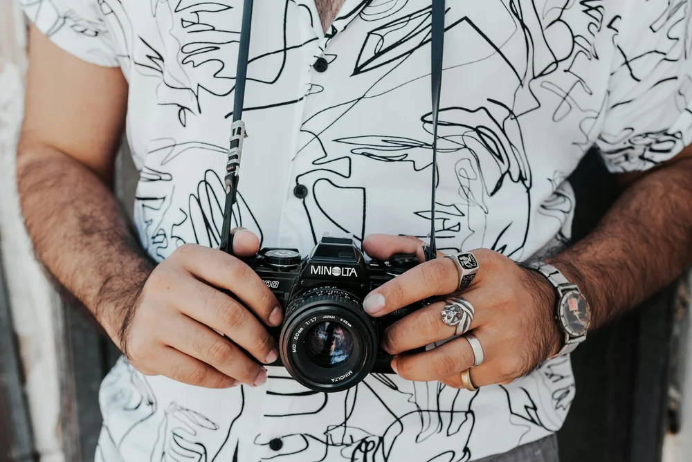 A close-up shot of a professional camera capturing a wedding scene, emphasizing the importance of high-quality equipment.