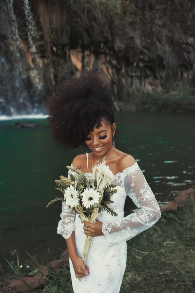 Bride holding a white bouquet by water