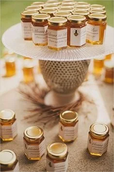 Mini honey jar wedding favours arranged around a honeycomb patterned vase