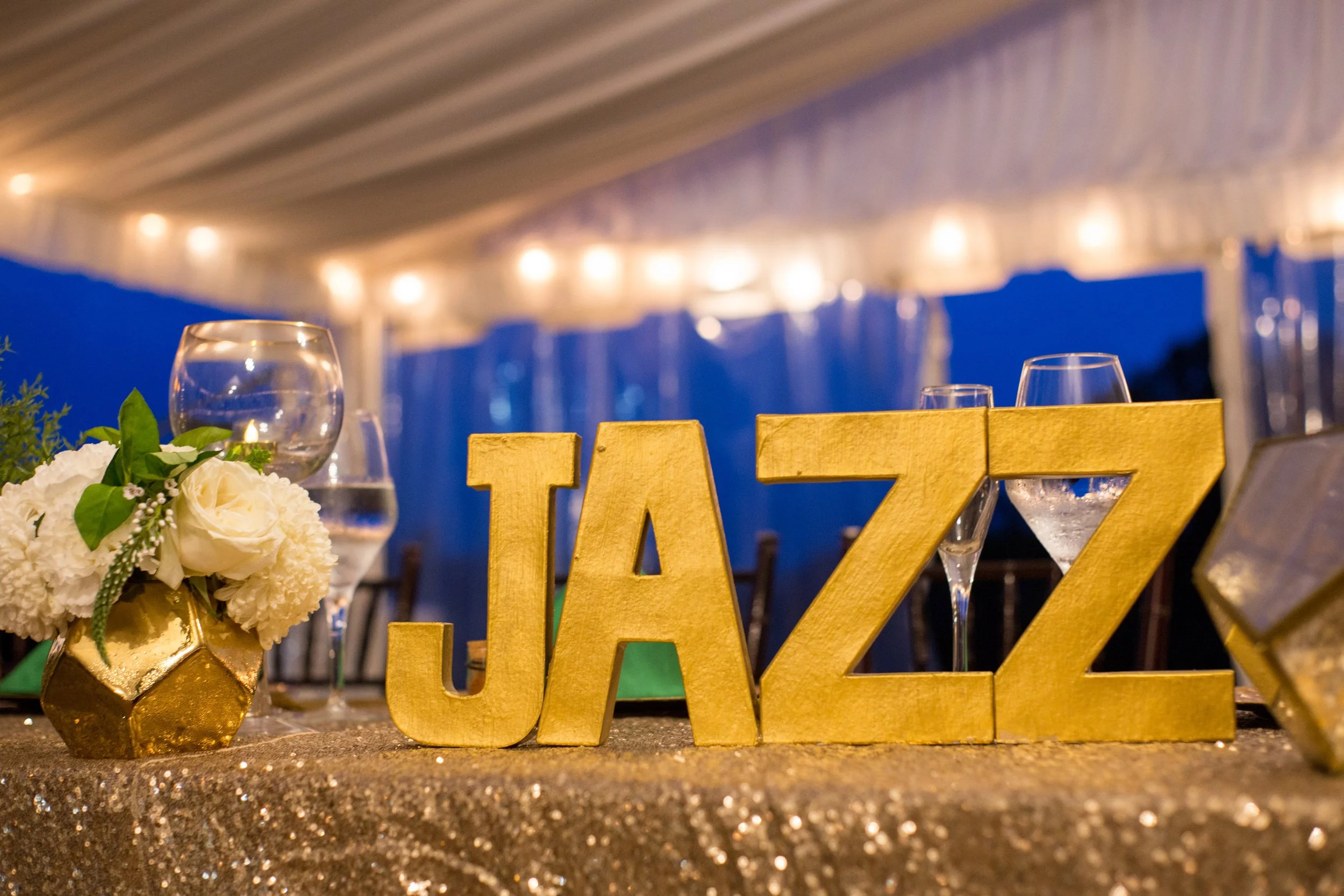 Gold JAZZ letter signage on a sequin linen at a themed reception