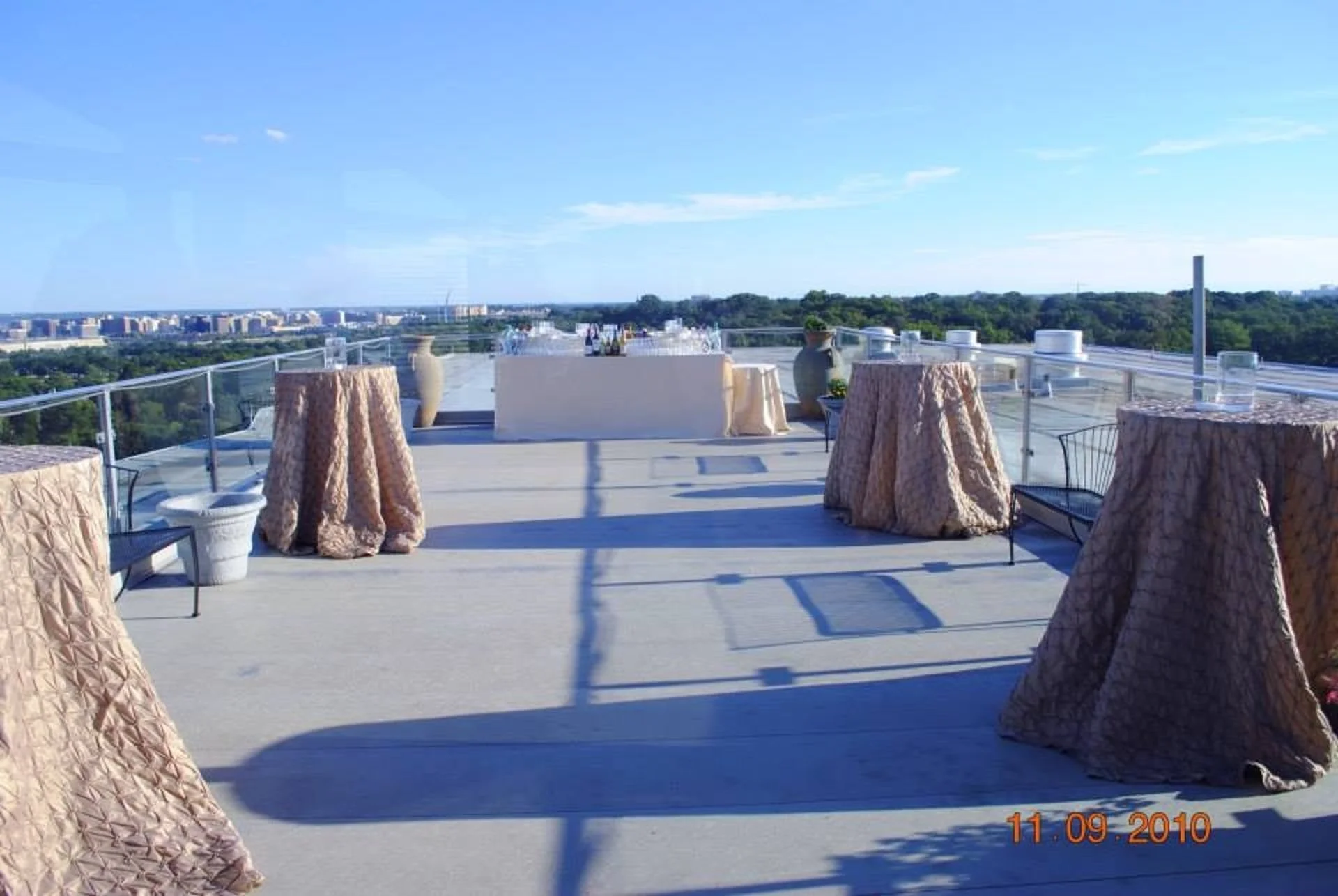 Rooftop event terrace set with cocktail tables in blush linens