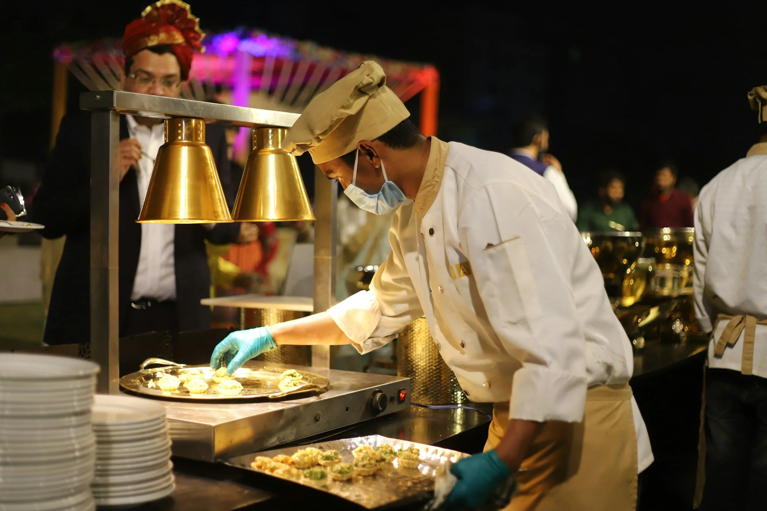Chef plating food at a catering station during an event