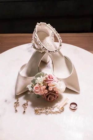 Bridal heels with a bow displayed with the wedding rings