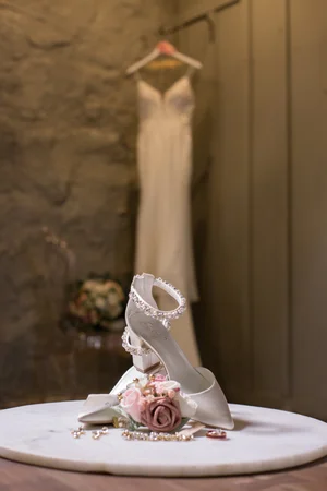Wedding gown hanging against a stone wall before the ceremony