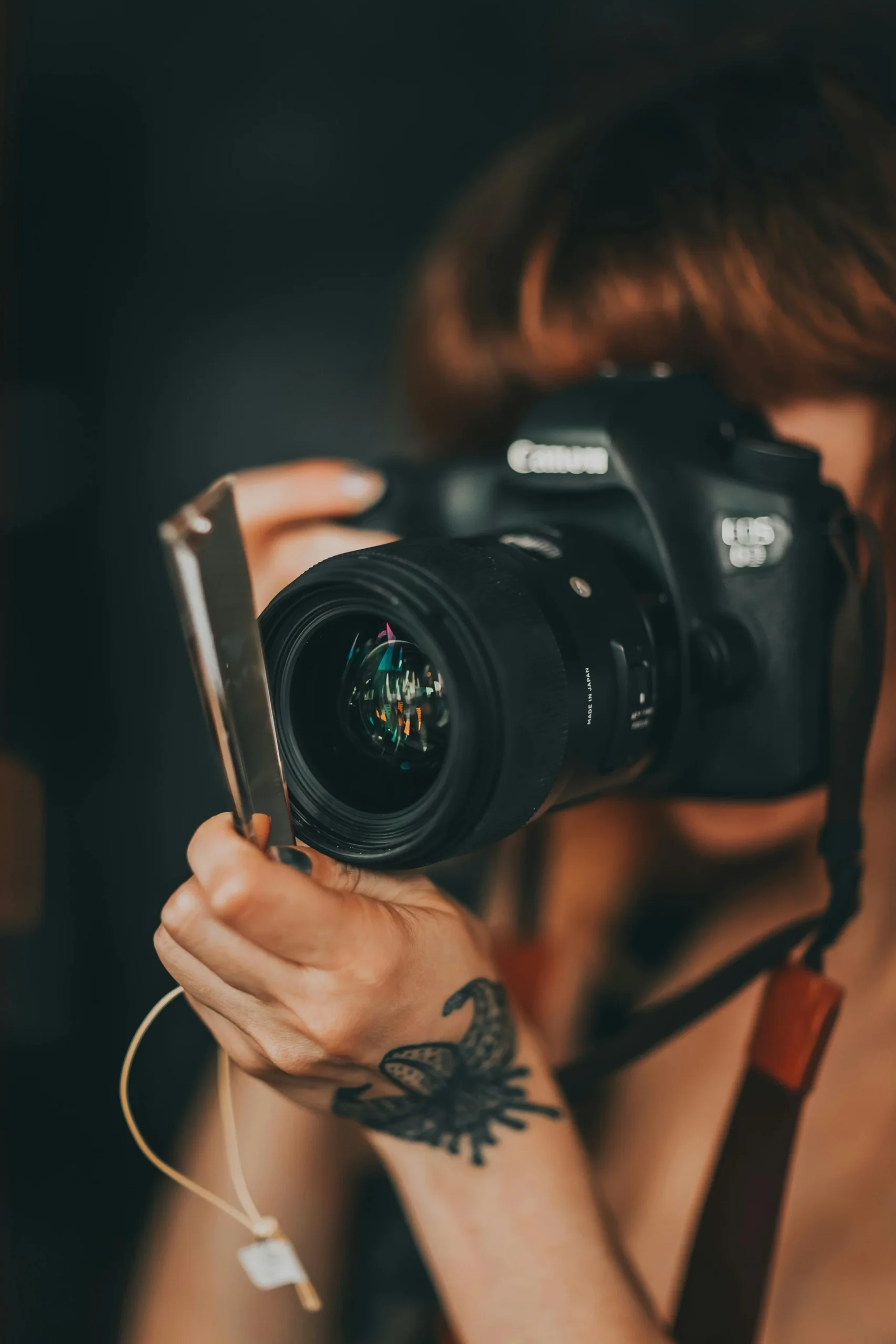 A professional photographer capturing a candid moment between the bride and groom during their wedding ceremony.