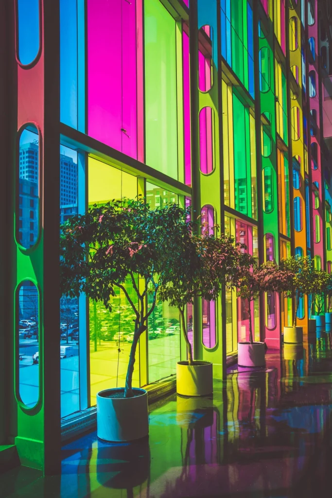 Colourful stained glass building facade with green trees on a city street