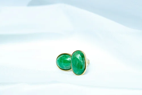 Pair of emerald green cufflinks on a soft white backdrop