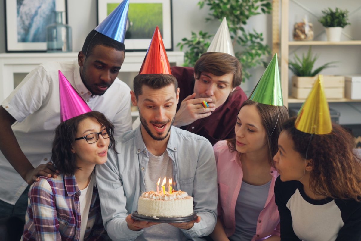 Guest laughing and pointing at the big reveal — the payoff when you host a surprise party well